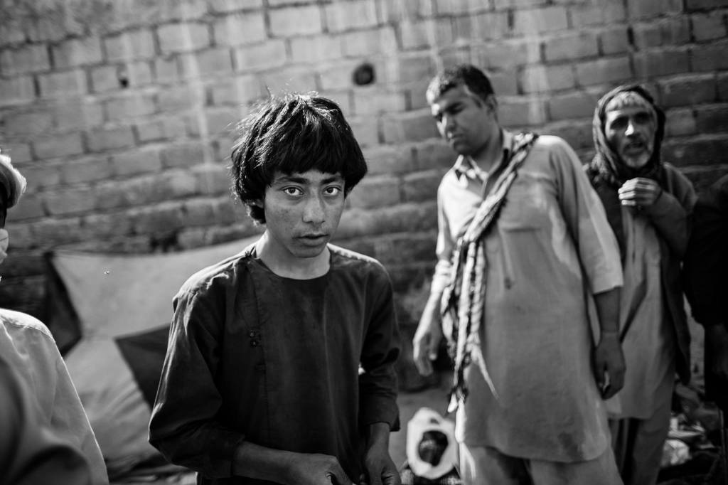 A youngster, addicted to heroin, stands with fellow addicts near the cemetery in Zaranj, Nimroz.