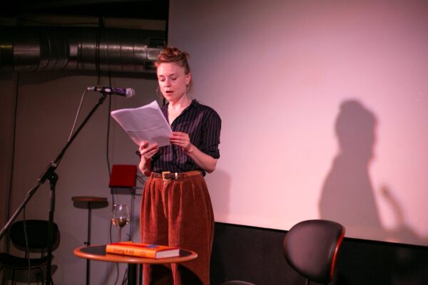 Ruby Russell reads from a paper at a Hostwriter event